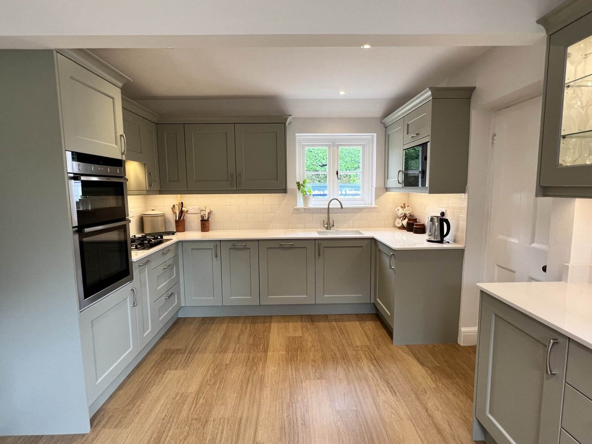 A beautifully designed kitchen in a Fleet home with sage green shaker cabinets